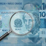 COPOM: O Futuro das Taxas de Juros no Brasil Dinheiro brasileiro com lupa, simbolizando a análise das taxas de juros pelo COPOM.