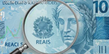 Dinheiro brasileiro com lupa, simbolizando a análise das taxas de juros pelo COPOM.